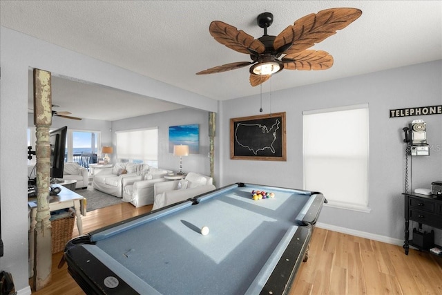 rec room with pool table, a textured ceiling, light wood-type flooring, and ceiling fan