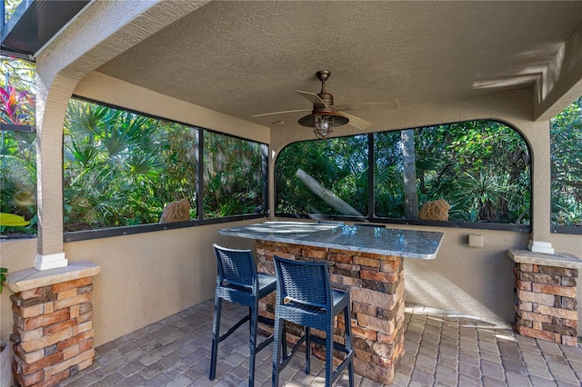 view of patio / terrace featuring ceiling fan and a bar