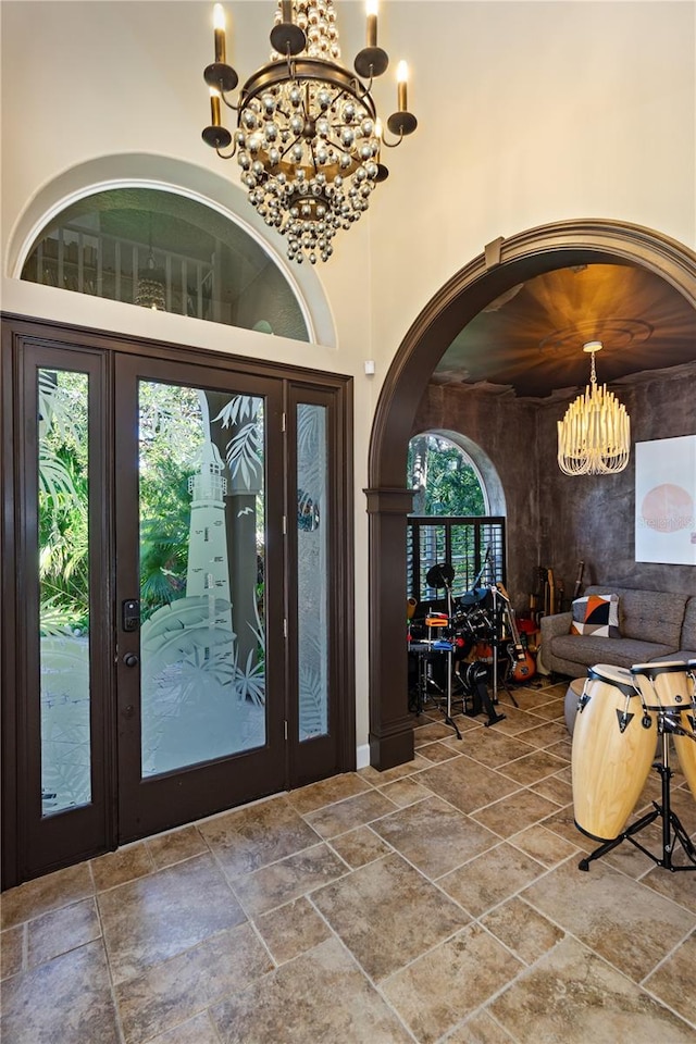 foyer with plenty of natural light, a high ceiling, and a chandelier