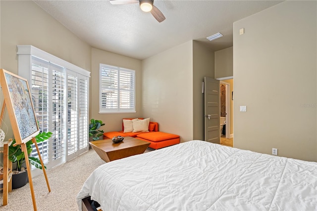 carpeted bedroom with a textured ceiling and ceiling fan