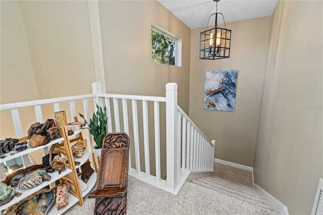 stairway featuring carpet floors and an inviting chandelier