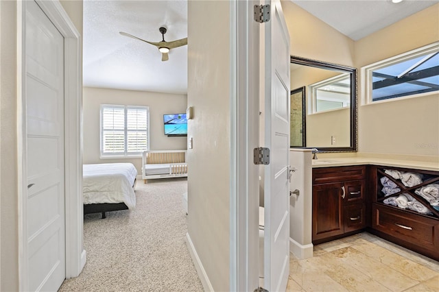 bathroom with a textured ceiling, ceiling fan, vanity, and vaulted ceiling