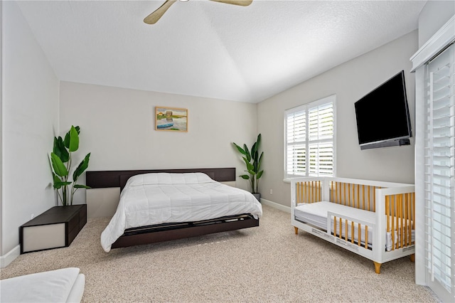 carpeted bedroom with ceiling fan and a textured ceiling