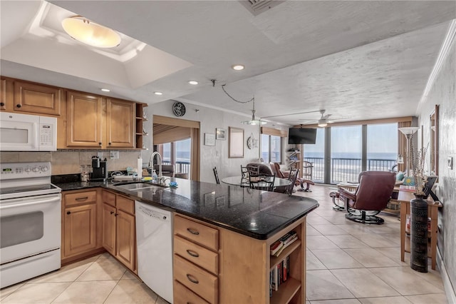 kitchen with kitchen peninsula, a wealth of natural light, sink, and white appliances