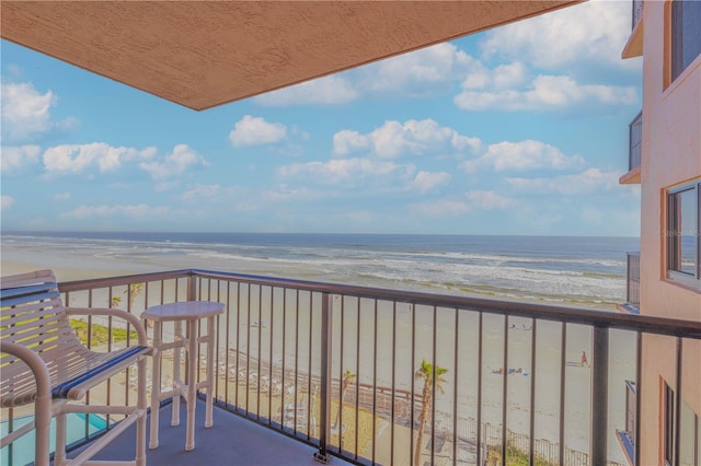 balcony featuring a water view and a beach view