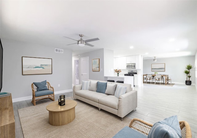 living room featuring light wood-type flooring and ceiling fan