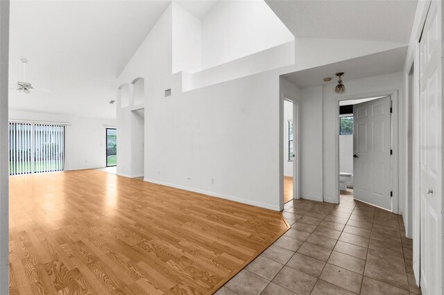 172 Gull Dr S, Daytona Beach, FL 32119 - unfurnished living room with high vaulted ceiling, ceiling fan, baseboards, and wood finished floors