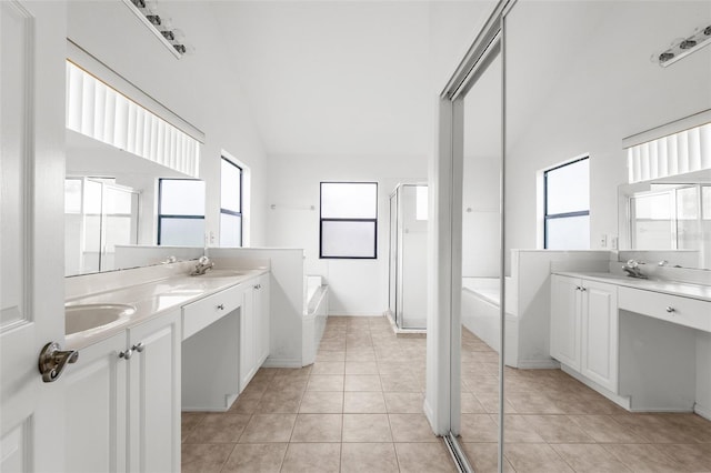 bathroom with vanity, independent shower and bath, vaulted ceiling, and tile patterned flooring