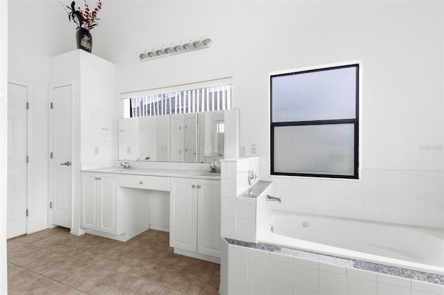 bathroom featuring vanity, tiled tub, and tile patterned floors