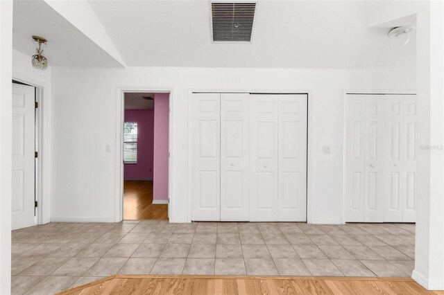 172 Gull Dr S, Daytona Beach, FL 32119 - unfurnished bedroom with light tile patterned flooring, two closets, and baseboards