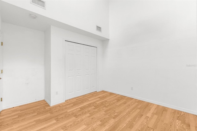 unfurnished bedroom with light hardwood / wood-style floors and a closet