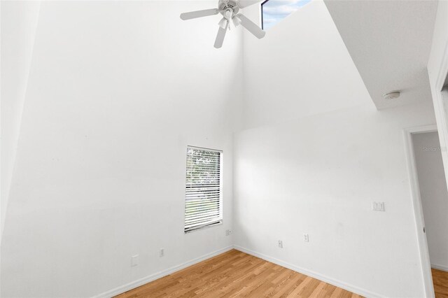 172 Gull Dr S, Daytona Beach, FL 32119 - spare room with light wood-type flooring, a ceiling fan, a smoke detector, baseboards, and a high ceiling