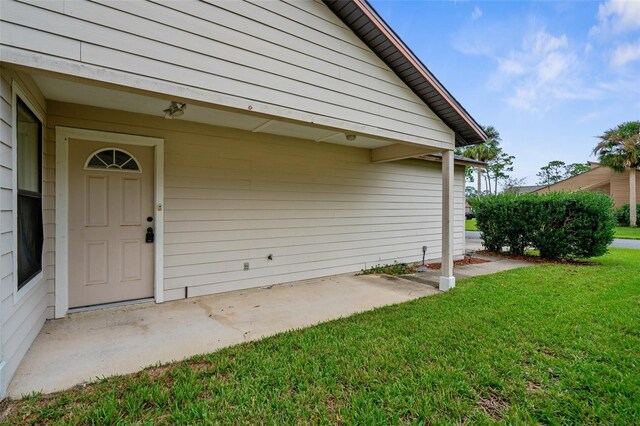 entrance to property featuring a lawn