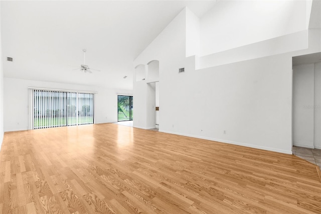 unfurnished living room with ceiling fan, high vaulted ceiling, and light wood-type flooring