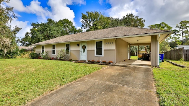 ranch-style house featuring a carport and a front lawn