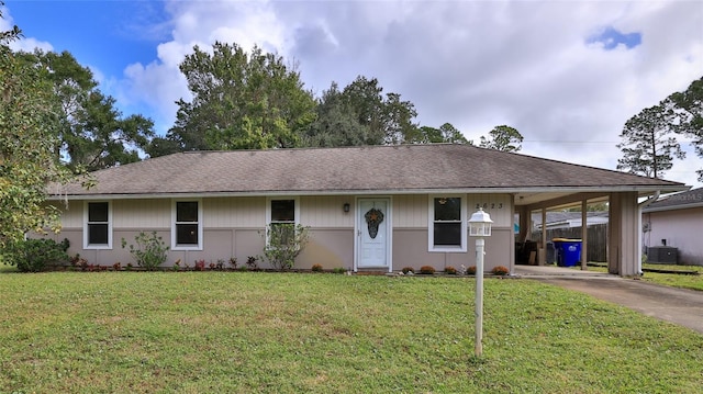 ranch-style home with cooling unit, a front lawn, and a carport