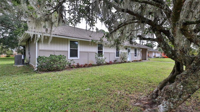 exterior space featuring central AC and a front lawn