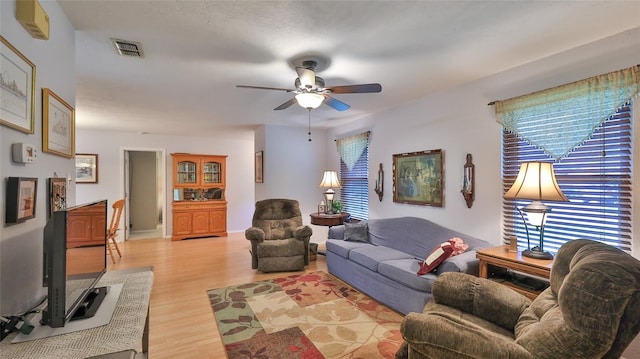 living room featuring ceiling fan and light hardwood / wood-style flooring