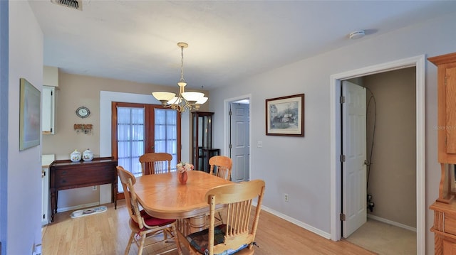 dining room featuring light hardwood / wood-style flooring and a notable chandelier