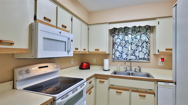 kitchen featuring sink, white cabinets, and white appliances