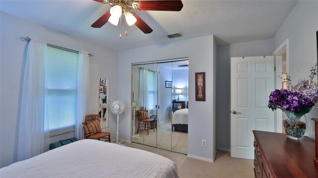 carpeted bedroom with a closet and ceiling fan