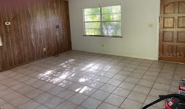 tiled spare room with wooden walls