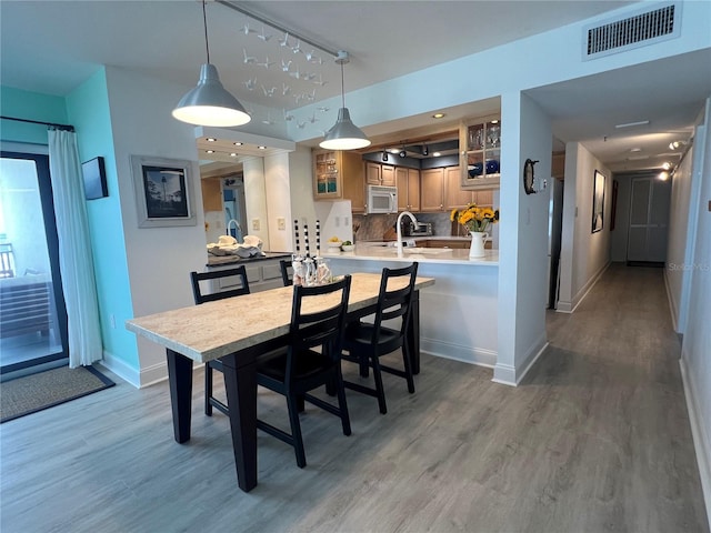 dining area featuring sink and wood-type flooring