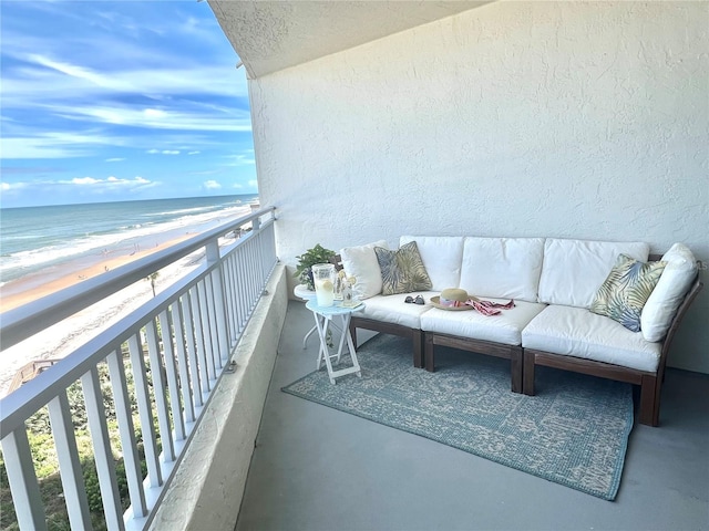 balcony with a water view and a view of the beach