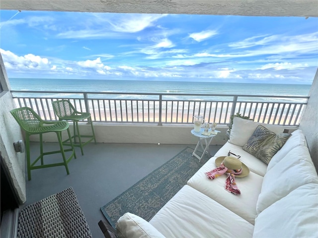 balcony featuring a water view and a beach view