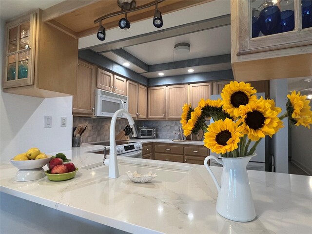 5207 S Atlantic Ave Unit 0622, New Smyrna Beach, FL 32169 - kitchen featuring brown cabinetry, a toaster, glass insert cabinets, white microwave, and tasteful backsplash
