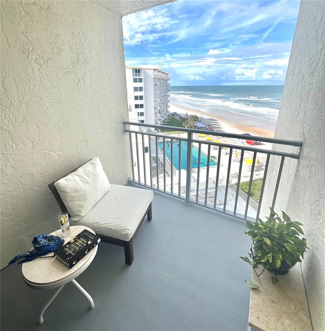 balcony with a water view and a beach view