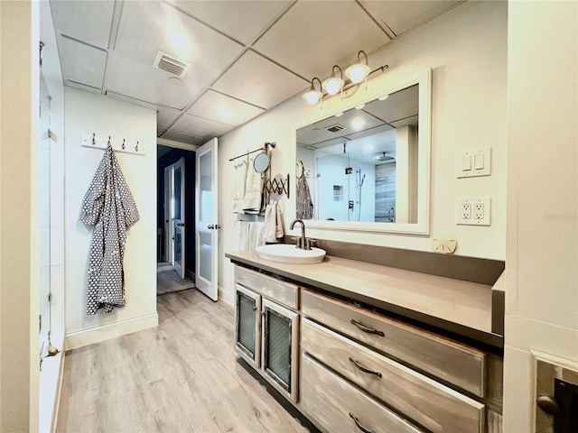 interior space with vanity, an enclosed shower, and hardwood / wood-style flooring