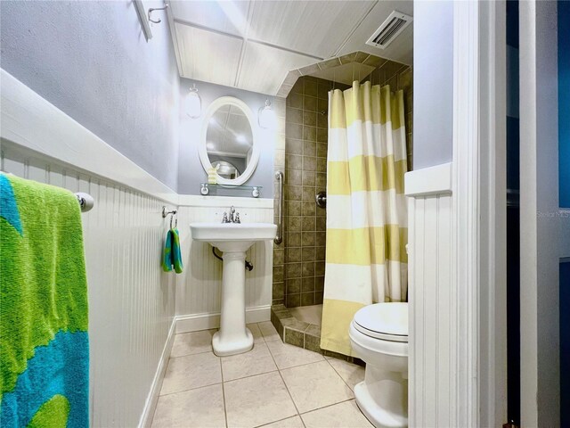 5207 S Atlantic Ave Unit 0622, New Smyrna Beach, FL 32169 - full bathroom featuring a sink, tile patterned flooring, toilet, visible vents, and tiled shower