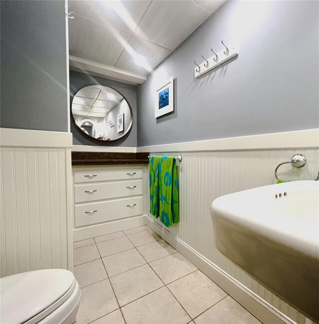 5207 S Atlantic Ave Unit 0622, New Smyrna Beach, FL 32169 - half bath featuring vanity, tile patterned floors, toilet, and a wainscoted wall