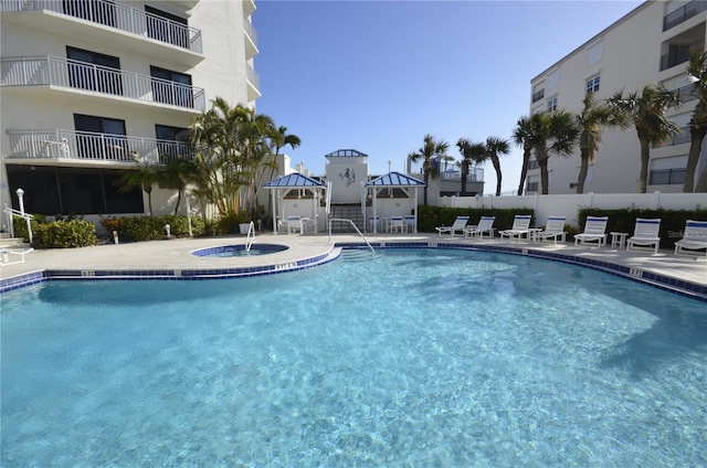 view of pool with a community hot tub, a gazebo, and a patio area