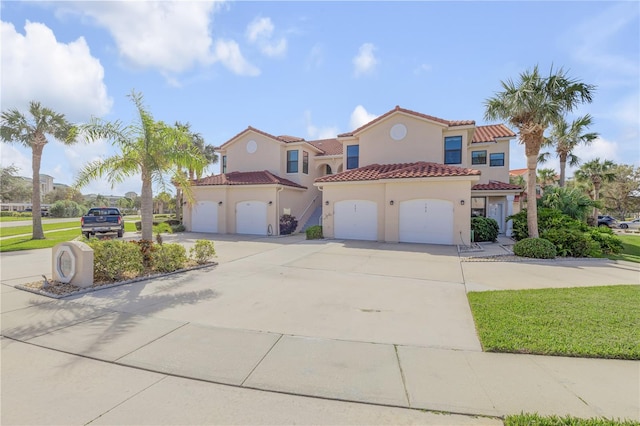 mediterranean / spanish home with a front lawn and a garage