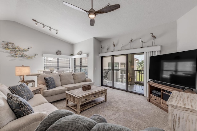 living room featuring a textured ceiling, ceiling fan, vaulted ceiling, track lighting, and light colored carpet