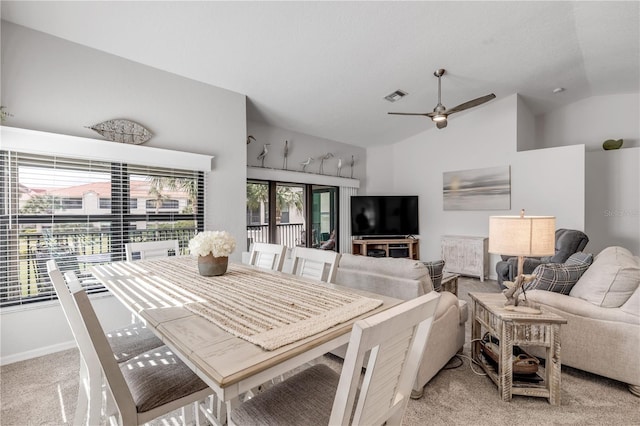 dining room with light carpet, ceiling fan, and vaulted ceiling