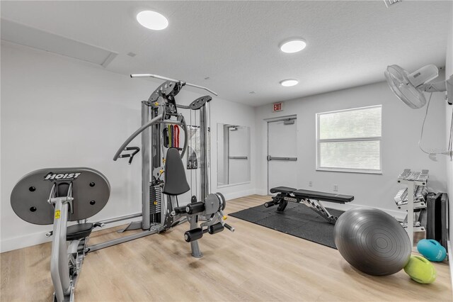 workout room featuring a textured ceiling and wood-type flooring