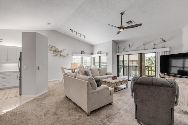 carpeted living room featuring ceiling fan, a textured ceiling, lofted ceiling, and track lighting