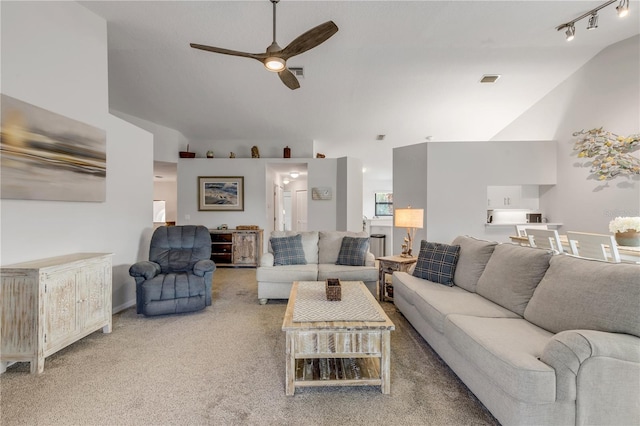 living room with lofted ceiling, track lighting, light carpet, and ceiling fan