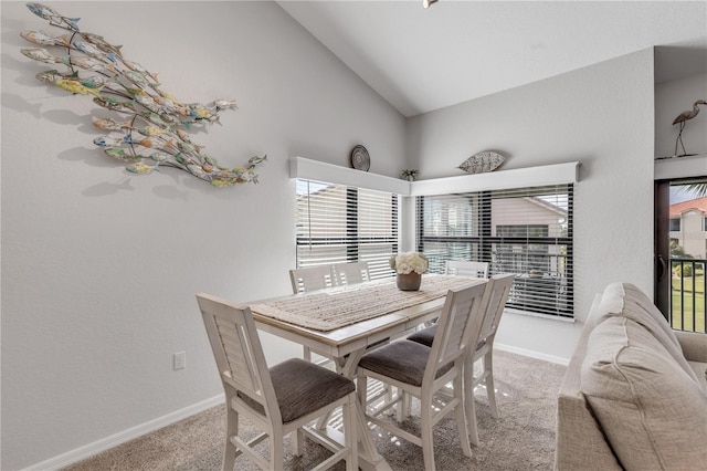 dining room with vaulted ceiling and carpet flooring