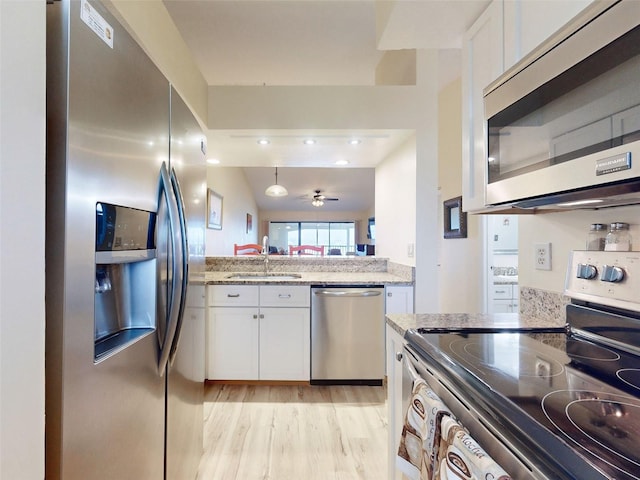 kitchen with white cabinetry, appliances with stainless steel finishes, sink, ceiling fan, and light hardwood / wood-style flooring