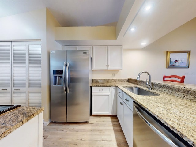 kitchen featuring white cabinetry, appliances with stainless steel finishes, lofted ceiling, and sink