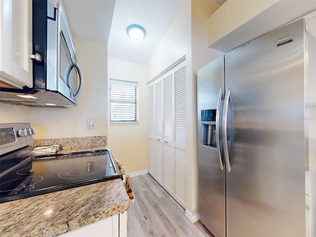 452 Bouchelle Dr Unit 303, New Smyrna Beach, FL 32169 - kitchen featuring stainless steel appliances, light wood-type flooring, baseboards, and white cabinets