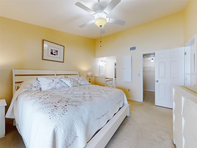 carpeted bedroom featuring ceiling fan, a walk in closet, and a closet