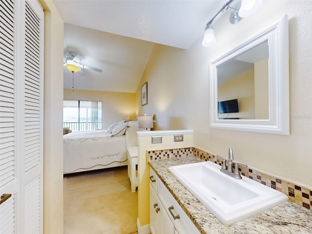 452 Bouchelle Dr Unit 303, New Smyrna Beach, FL 32169 - ensuite bathroom with a closet, vanity, tasteful backsplash, vaulted ceiling, and a ceiling fan
