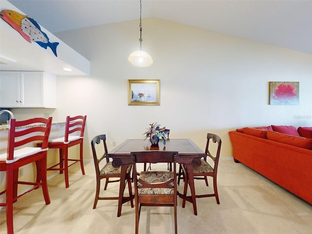 dining room with light colored carpet and lofted ceiling