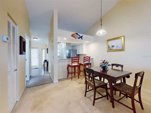 carpeted dining area with vaulted ceiling