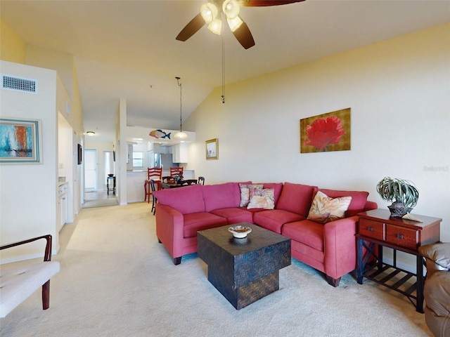 living room with lofted ceiling, light colored carpet, and ceiling fan